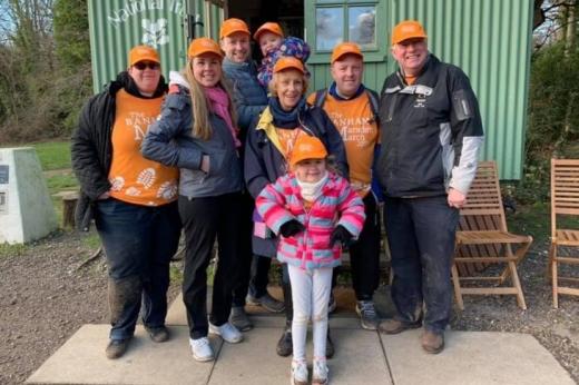 Christine and Family outdoors wearing their orange Marsden March shirts and caps 