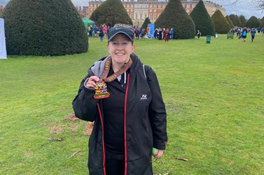 Team Marsden runner posing with her medal in the Hampton Court Palace grounds