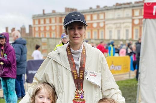 Team Marsden runner and her two children in front of Hampton Court Palace with her medal