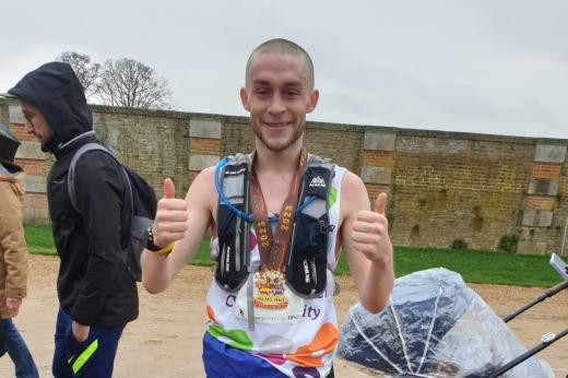 Team Marsden runner giving a thumbs up with his medal