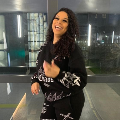 Courtney dressed in a black tracksuit, smiling