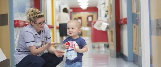 Toddler and nurse in corridor