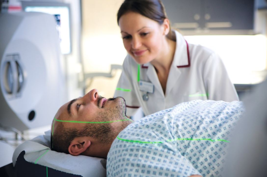 A man undergoes initial laser scanning before radiotherapy