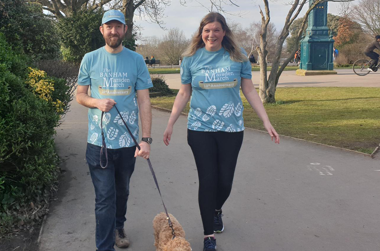 a man and a woman fundraising and walking their dog