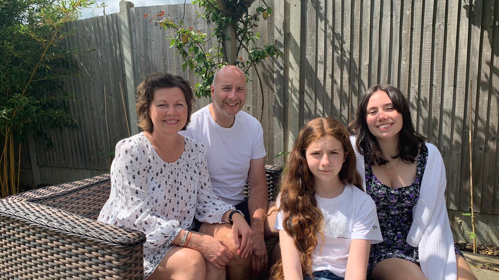 Sally sitting in the garden with her family