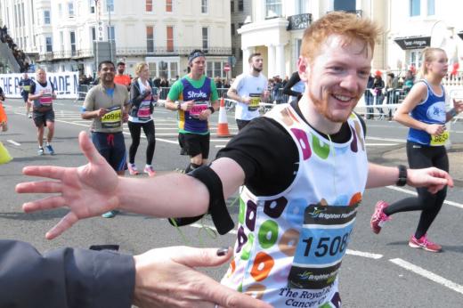 Brighton Marathon supporter high fives a smiling runner. 