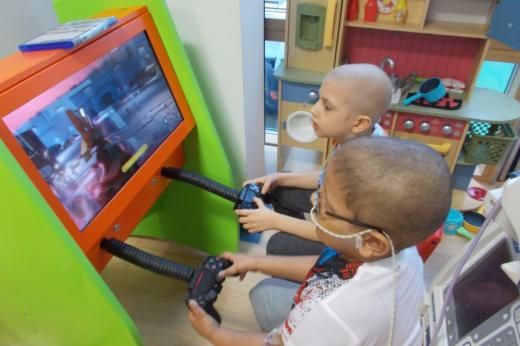 Two young patients play a video game together