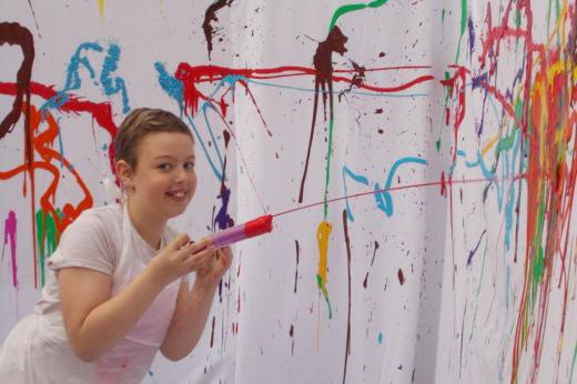 Young patient playing with paint syringe