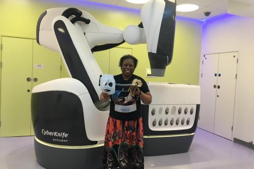 Miranda standing in-front of the CyberKnife tech at The Royal Marsden