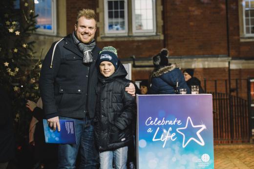 Matt and Brock at the Celebrate A Life Service 2018, standing next to the speaker podium and Christmas tree