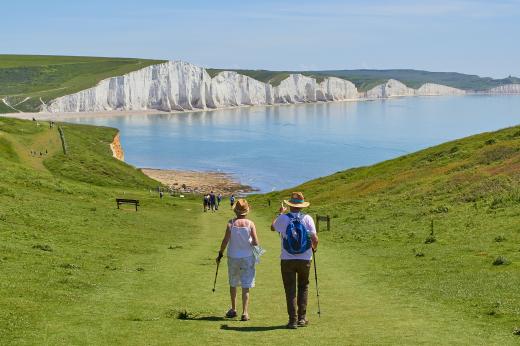 A couple hiking on the South Downs. The Seven sisters cliffs are in the background