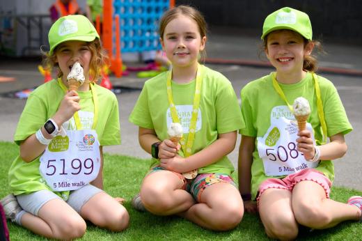 Three smiling young children wearing their Banham Marsden March medals and eating ice-cream