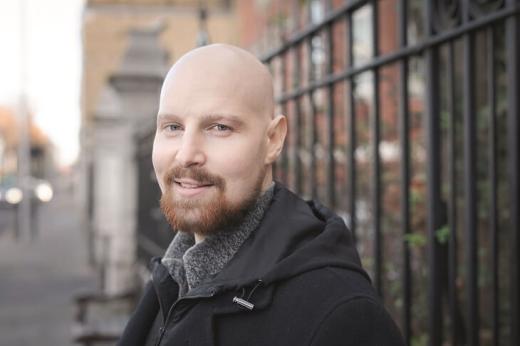 Alastair, wearing a black coat, standing outside The Royal Marsden Chelsea main entrance