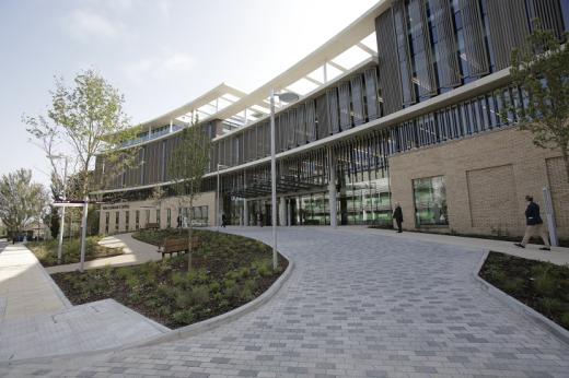 The outside of the Oak Cancer Centre on a sunny day - a brand new building with floor to ceiling windows and steel columns 