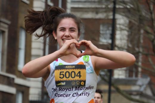 A Team Marsden runner makes a heart at the camera during London Landmarks 2023