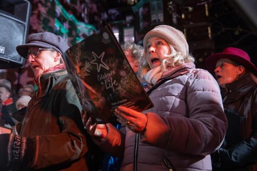 A man and woman singing carols at a Celebrate a Life carol service