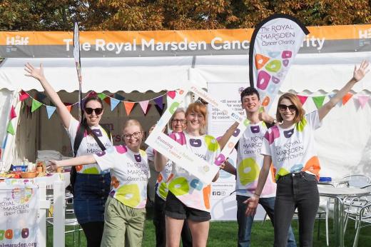 A group of people in Royal Marsden Cancer Charity-funded t-shirts standing in front of a marquee