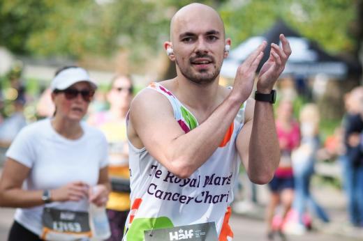 A runner at Royal Parks Half Marathon, clapping and smiling 