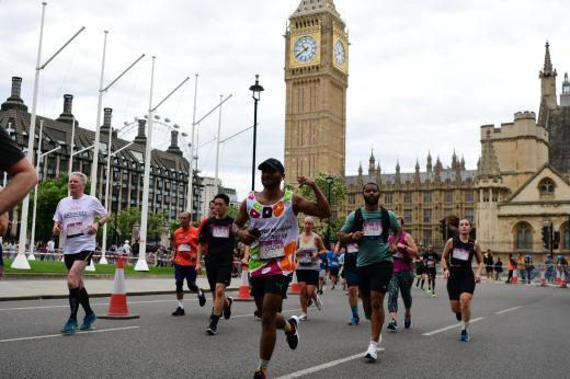A Royal Marsden supporter running with Big Ben behind him 