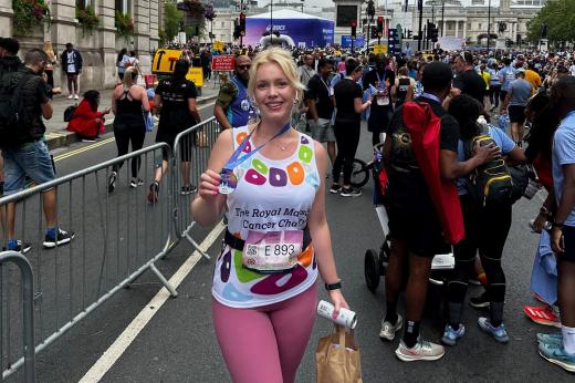 A supporter stands with her medal in front of Nelson's Column