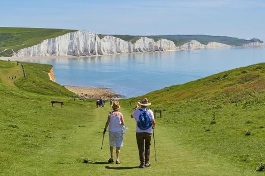 A couple hiking on the South Downs. The Seven sisters cliffs are in the background