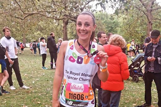 Team Marsden runner in St James' park holding a medal and smiling