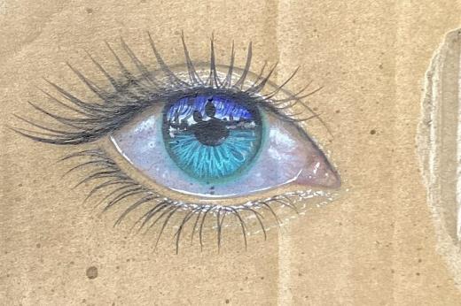 A colourful pencil drawing of a blue eye on cardboard-looking material