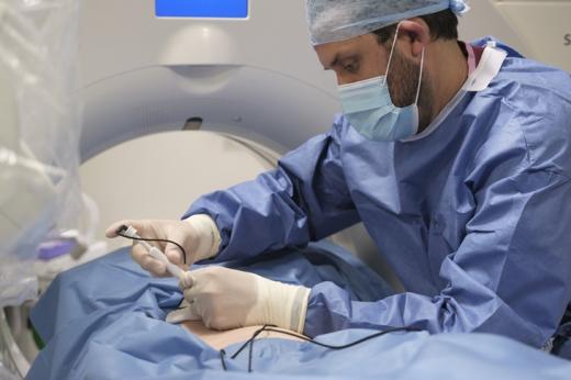 Surgeon in blue scrubs performing lung ablation on patient