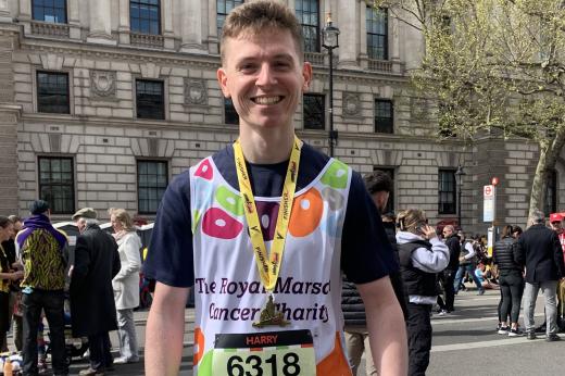 Runner smiles in Royal Marsden Cancer Charity vest 