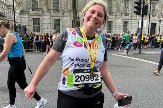 Woman smiles in RMCC vest with medal around her neck 