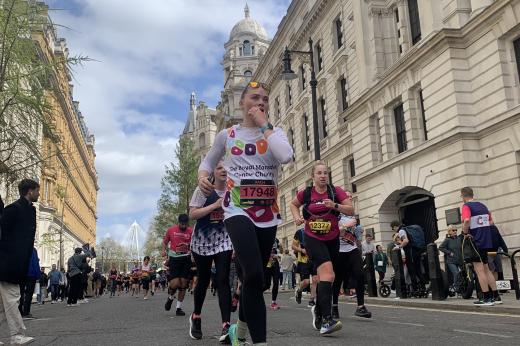 Runner runs down London street in Royal Marsden Cancer Charity vest