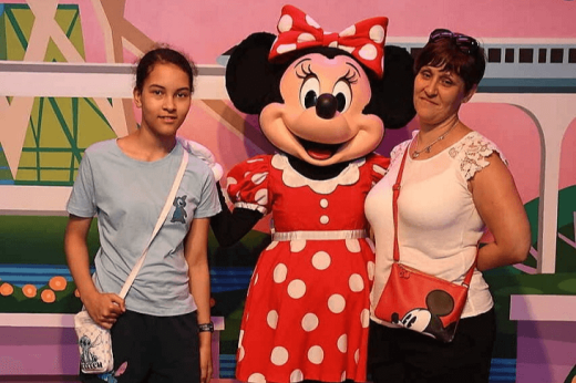 Roxanne with her young daughter, standing next to Minnie mouse at Disneyland