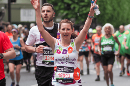 Jo with her hands up running the London Marathon 2024