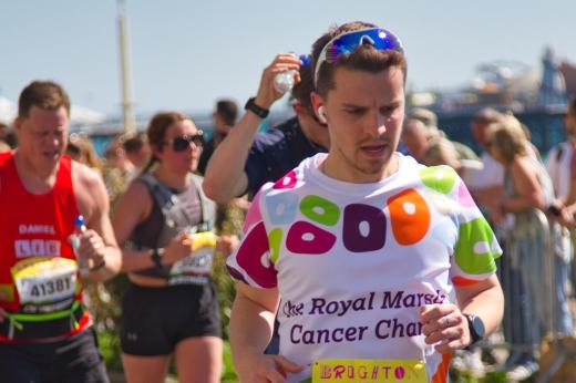 Royal Marsden runner with sunglasses on his head and earphones in. The pier and runners are in background