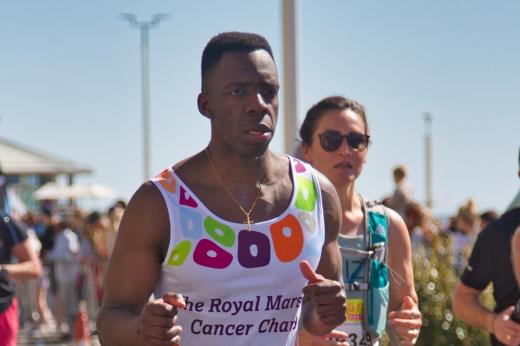 Royal Marsden runner looking determined. There is a runner in the background and the photo is zoomed in.