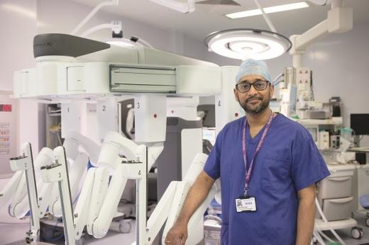 Professor Vinidh Paleri in blue scrubs and a Royal Marsden lanyard around his neck