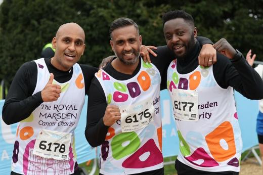Three RMCC runners smiling to the camera with their arms around each other 