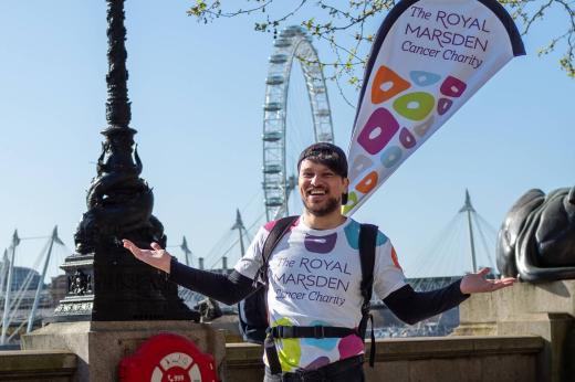 RMCC volunteer and staff member smiling with the banner on his back with London Eye in the background
