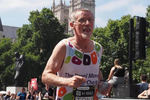 RMCC runner running through London with runners and supporters in the background. 