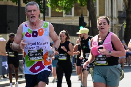 RMCC runner with daughter looking at the camera running through London with runners in the background. 
