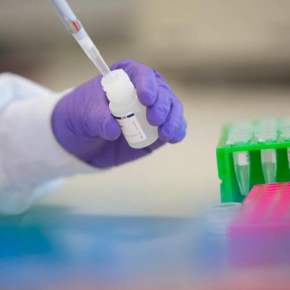 Researcher's hands with genetics testing kit