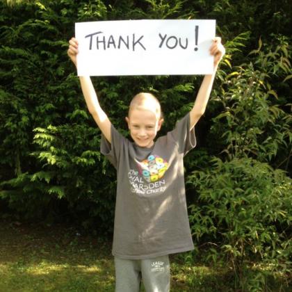 Jim's son Joseph holding up a Thank you! sign