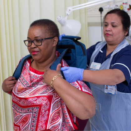 Nurse helping patient with backpack