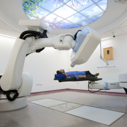 Image of the cyberknife machine with a patient lying down under it