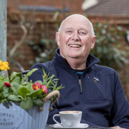 Keith sitting at cafe table with coffee