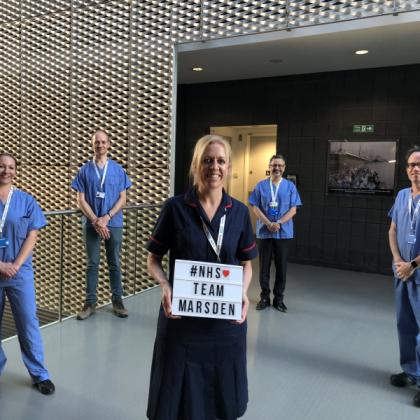 Staff standing as a group, with one holding a sign saying #NHS Team Marsden