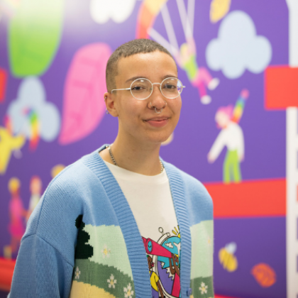 Artist Ahston Attzs with their mural in the OCCYP