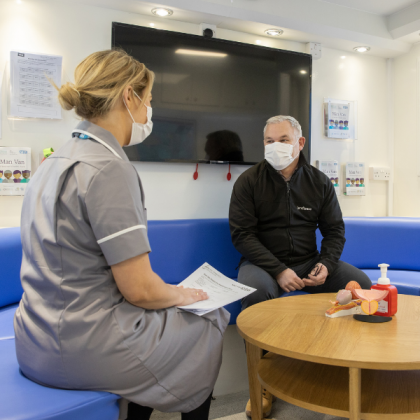 Royal Marsden Nurse and patient wearing facemasks having a consultation inside the Man Van