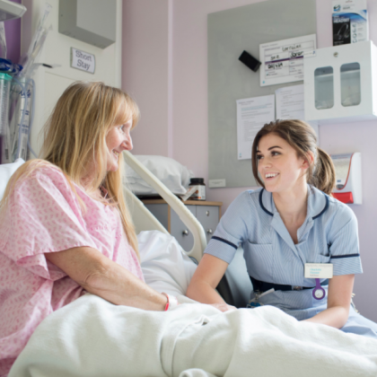 Photo of a Patient and a Nurse smiling at one another
