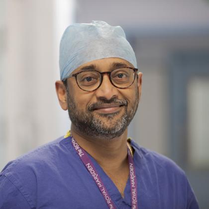 Professor Vinidh Paleri smiling, wearing blue scrubs and a Royal Marsden lanyard